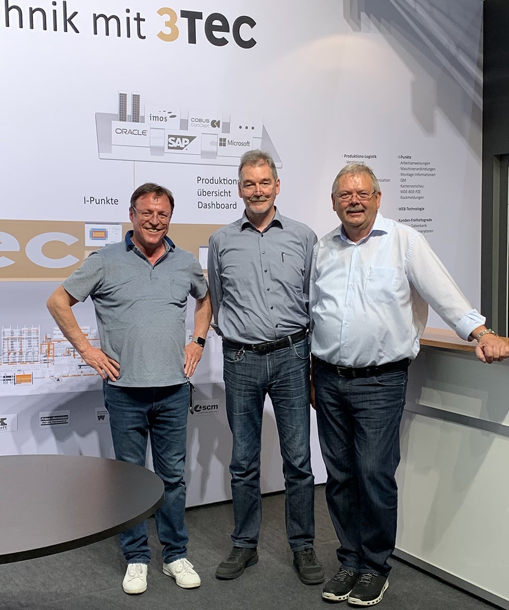 Drei Männer stehen vor einem 3Tec-Messestand.